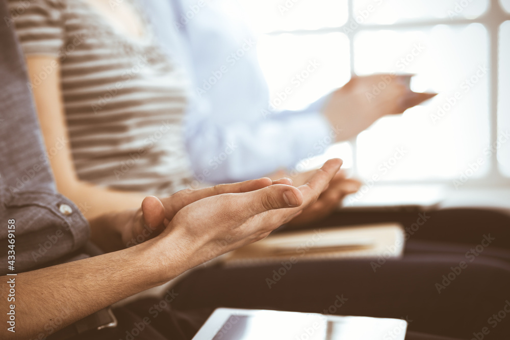 Business people clapping at meeting or conference, close-up of hands. Group of unknown businessmen and women in modern white office. Success teamwork, corporate coaching and applause concept