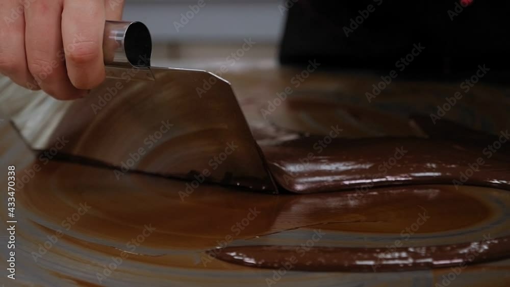 Tempering of the chocolate on the metal surface in the pastry shop.