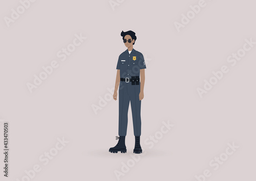 A young male police officer on duty wearing a uniform and sunglasses