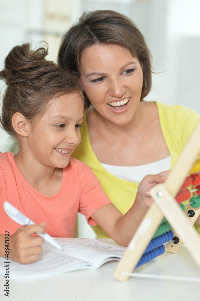 Portrait of a beautiful little cute girl reading book with mother Portrait of a beautiful little cute girl reading book with mother