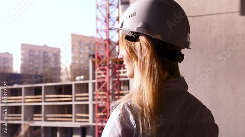 Young beautiful female builder in a white construction helmet. Professional Woman Working in the Modern Construction Industry.