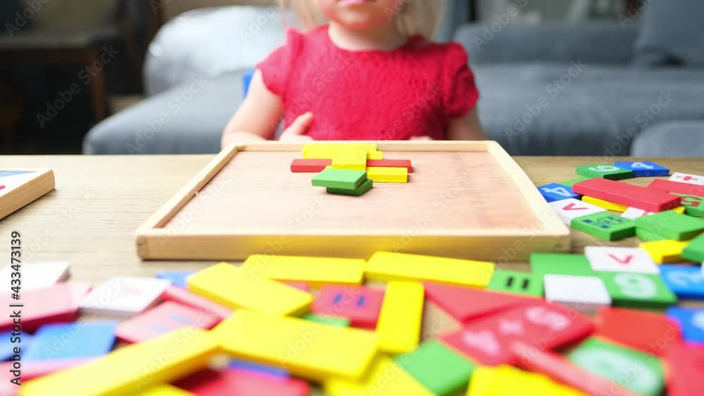 child, baby, blonde girl plays with colored wooden cubes, builds houses and rockets, the concept of the development of creativity, fine motor skills, patience and perseverance child, baby, blonde girl plays with colored wooden cubes, builds houses and rockets, the concept of the development of creativity, fine motor skills, patience and perseverance