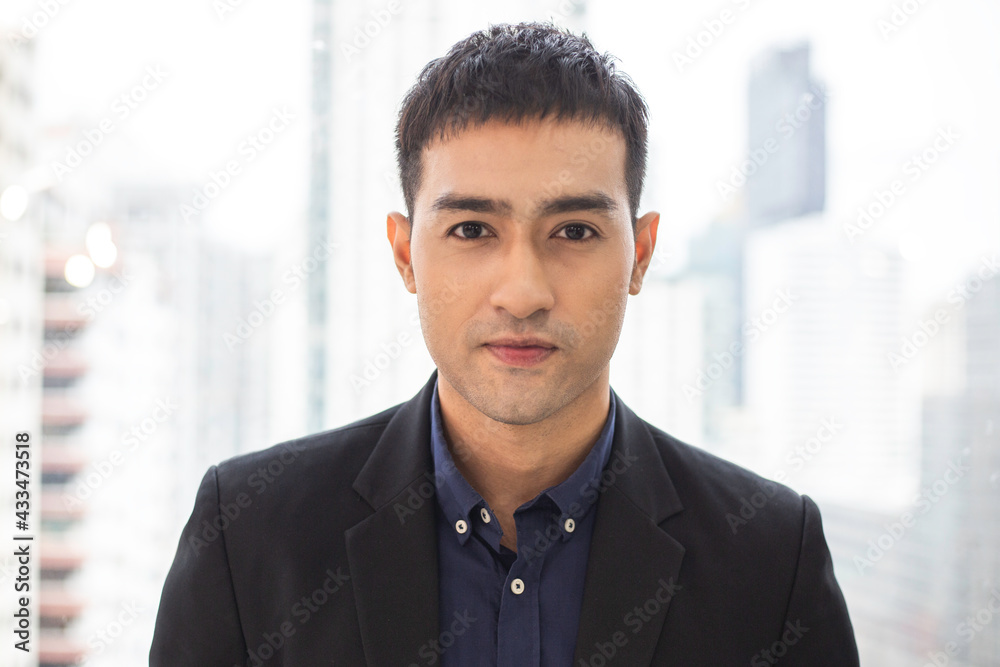 Portrait of confident Asian businessman standing in the office with financial district background. man look at camera. corporate business in company. copy space Portrait of confident Asian businessman standing in the office with financial district background. man look at camera. corporate business in company. copy space