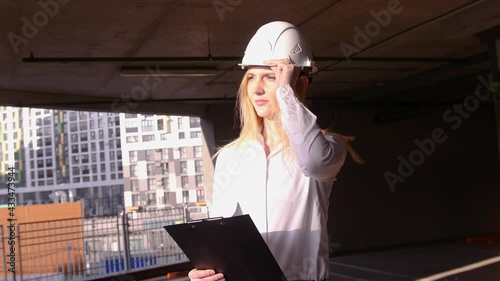 Young beautiful female builder in a white construction helmet. Professional Woman Working in the Modern Construction Industry.