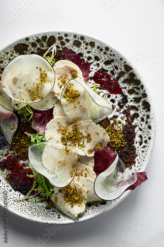 Close up on traditional italian cuisine Vitello tonnato. A dish with pickled veal with tuna cream sauce and bread on wooden background. Copy space for design, text. Snack before lunch. Close up food. photo