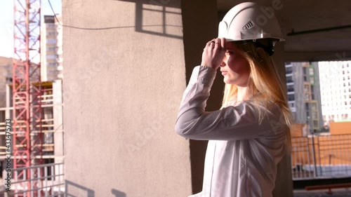 Young beautiful female builder in a white construction helmet. Professional Woman Working in the Modern Construction Industry.