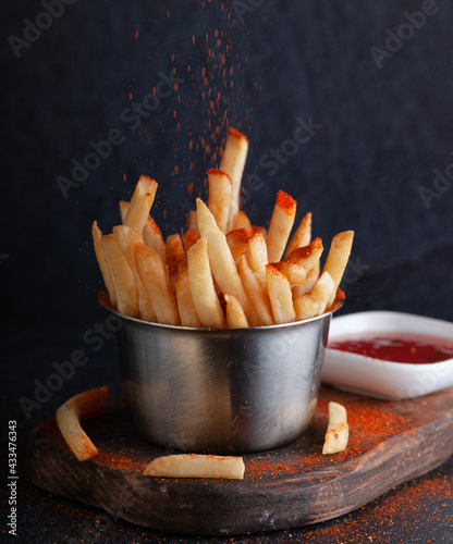 french fries with paprika in an iron bucket with sauce