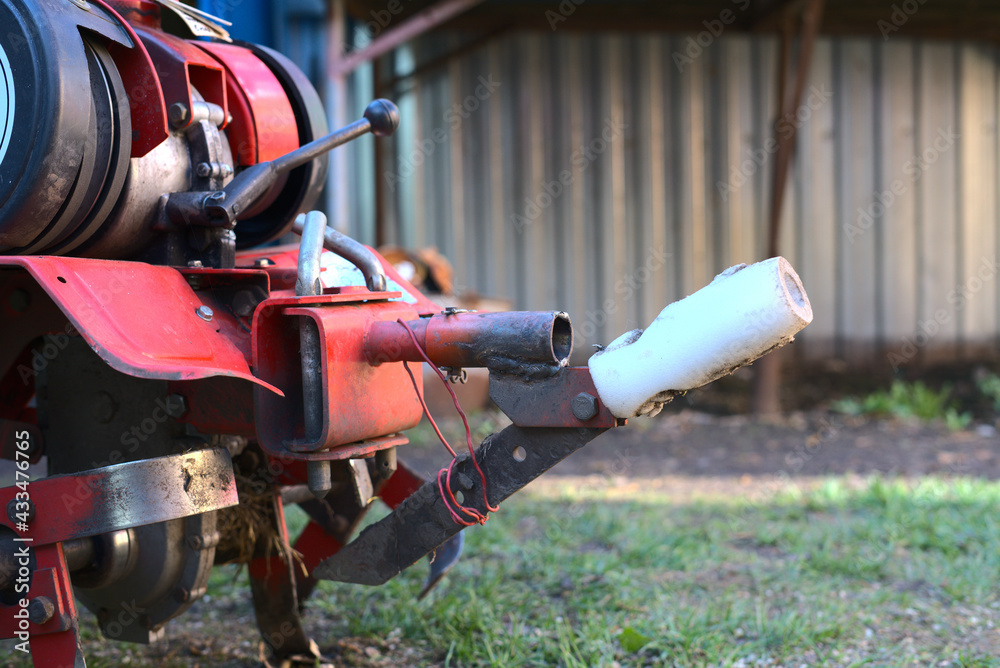 A mini tractor for plowing the land stands in the farmyard. Closeup A mini tractor for plowing the land stands in the farmyard. Closeup