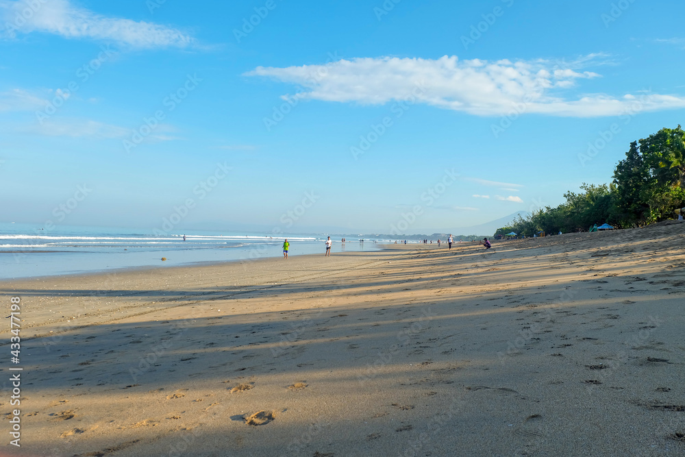 Kuta, Bali, Indonesia (2 May 2021): Kuta beach in the morning. Some local people are doing sports (jogging)