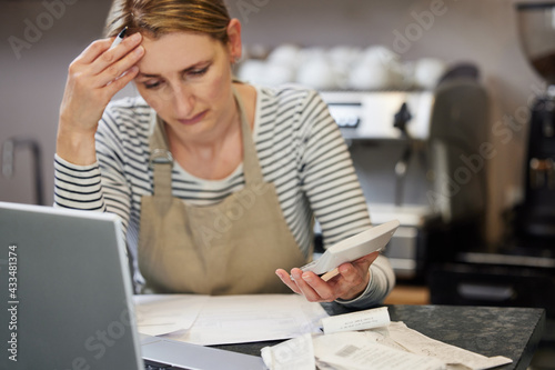 Foto Worried Female Owner Of Coffee Shop In Financial Difficulty Looking Through Bill