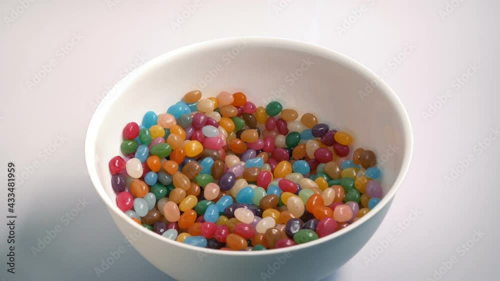 Man Grabs Handfuls Of Candy Beans From Bowl Man Grabs Handfuls Of Candy Beans From Bowl