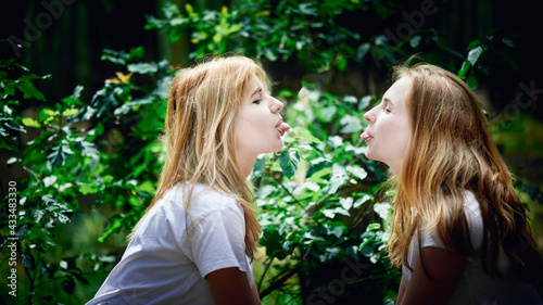 Two Young Women Showing Tongues To Each Other