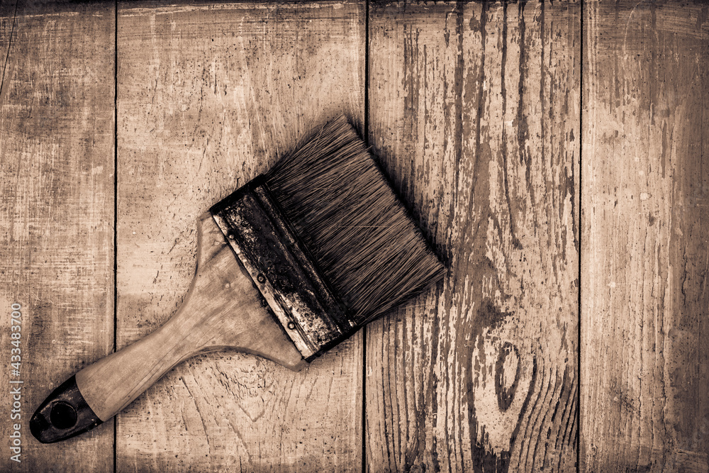 Old paint brush on old wooden table covered with blue paint. View from above Old paint brush on old wooden table covered with blue paint. View from above