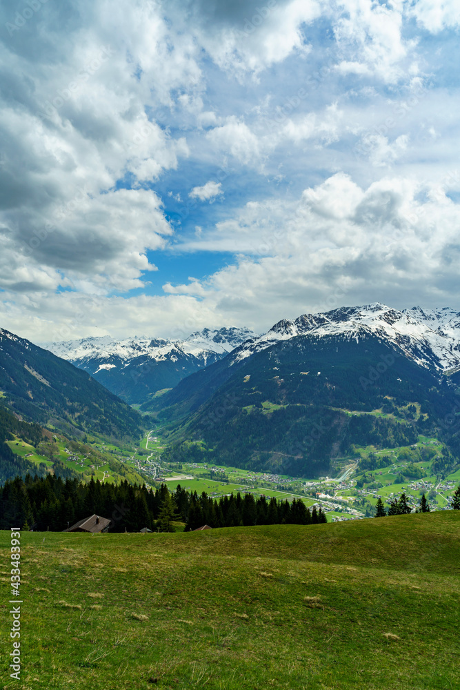 Blick von Bartholomäberg durch das Montafon zu den schneebedeckten Bergen des Rhätikon und Verwall im Vorarlberg. blumenübersäte Alpwiesen im Frühling und eine Föhnstimmung, blue cloudy sky with storm Blick von Bartholomäberg durch das Montafon zu den schneebedeckten Bergen des Rhätikon und Verwall im Vorarlberg. blumenübersäte Alpwiesen im Frühling und eine Föhnstimmung, blue cloudy sky with storm