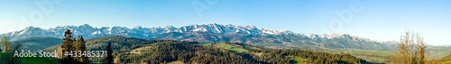 Obraz na płótnie Extra wide panorama of the Tatra Mountains with trees, forests and meadows in Podhale region in Poland. Early morning in spring, sunrise light w salonie