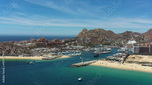 Aerial panoramic view of the Marina in Cabo San Lucas, the drone flying in El Medano Beach with a blue sky as background.