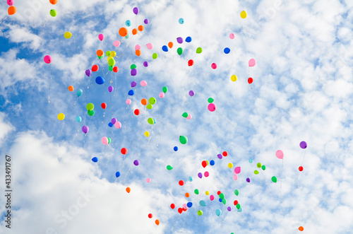 Lots of colorful balloons flying against blue sky with clouds with copy space. Concept of holiday, festival, Children's Day, Last call at school and kindergarten, birthday.