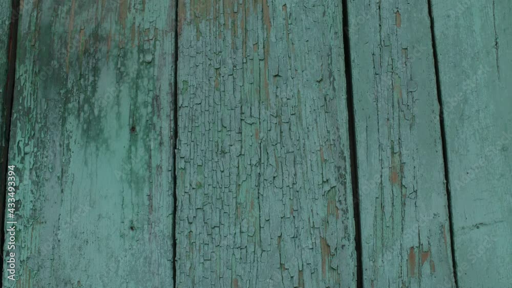 Wooden surface with crumbling paint. Textured background of old lumber surface with crumbling turquoise paint outside shabby building Wooden surface with crumbling paint. Textured background of old lumber surface with crumbling turquoise paint outside shabby building