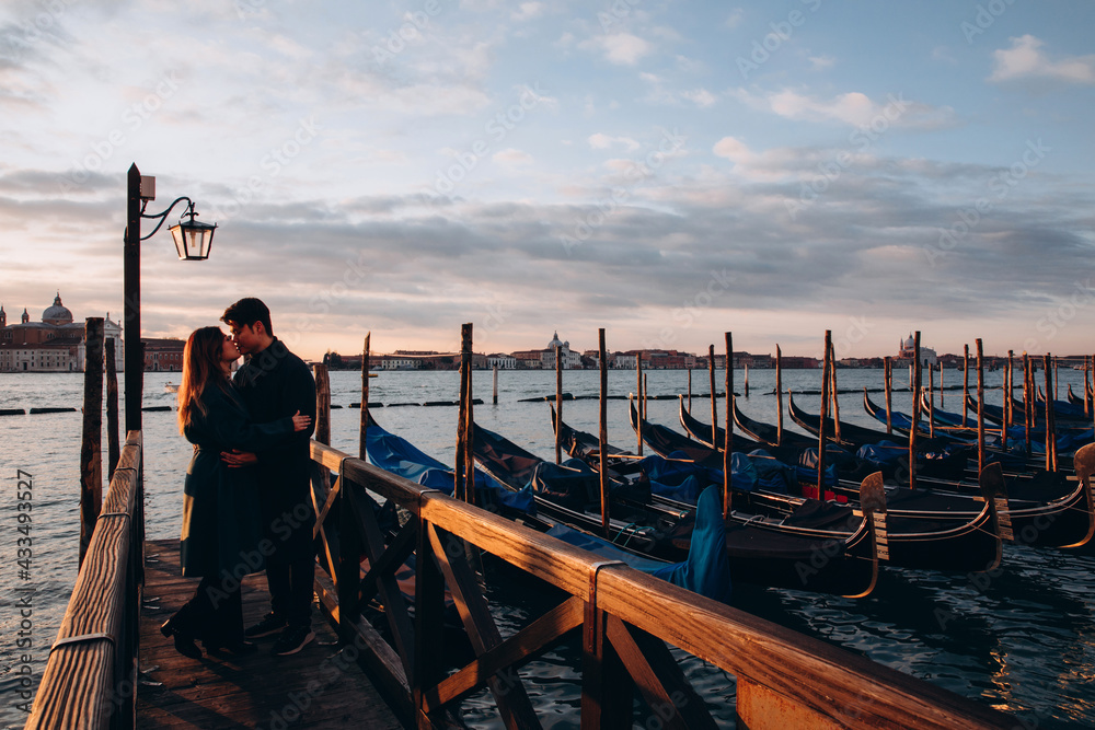 A romantic evening walk by a young Asian couple at the pier. A young couple travels to Venice.