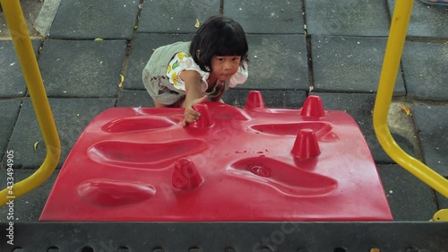 Happy asian kid adorable are playing at the playground, kids having fun playing with climbing the wall, activities kids, enjoy and leaning outdoor of kids concept, in summer time.