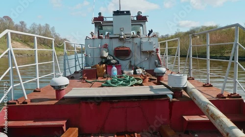 View of tug board. Tug sails on river outside Moscow. Sunny spring afternoon. photo