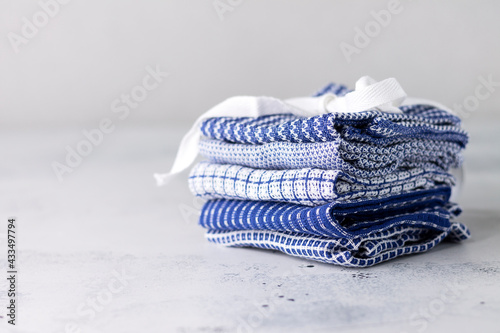 Textiles. Napkins made of cotton for home and serving in blue with a different pattern are stacked on a light background with a copy of the space.