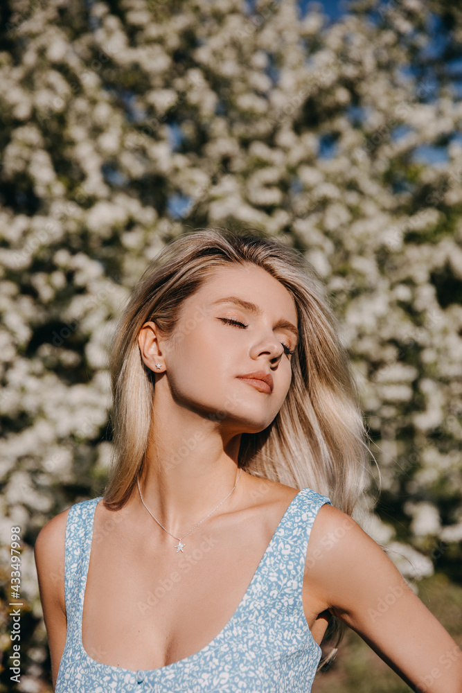 Portrait of a young woman with long blonde hair outdoors, in a park, enjoying sunny weather. Portrait of a young woman with long blonde hair outdoors, in a park, enjoying sunny weather.
