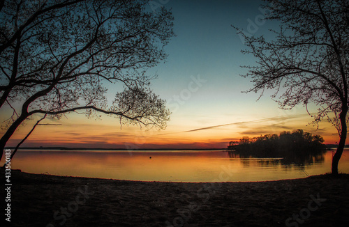 sunset over golden water with birds and clouds