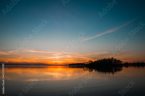sunset over golden water with birds and clouds
