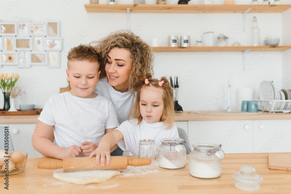 happy family in the kitchen. mother and children preparing the dough, bake cookies happy family in the kitchen. mother and children preparing the dough, bake cookies