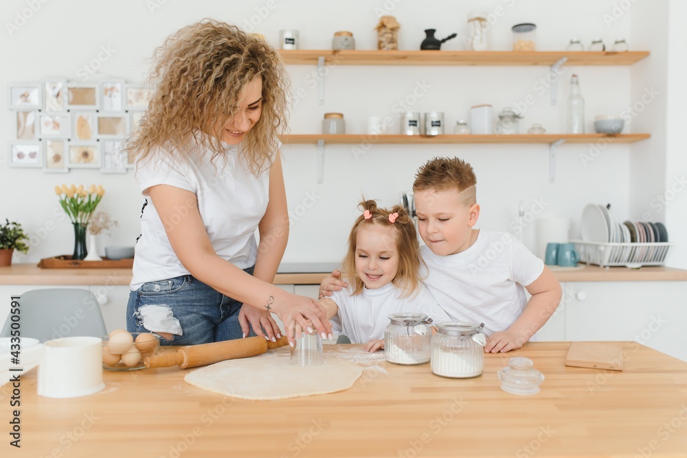 happy family in the kitchen. mother and children preparing the dough, bake cookies happy family in the kitchen. mother and children preparing the dough, bake cookies