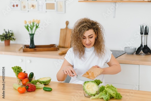 Young woman preparing vegetable salad in her kitchen. Healthy lifestyle concept beautiful woman with mixed vegetable.