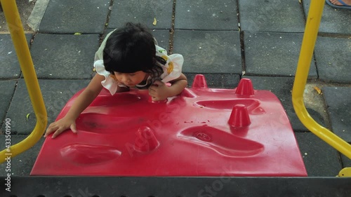 Happy asian kid adorable are playing at the playground, kids having fun playing with climbing the wall, activities kids, enjoy and leaning outdoor of kids concept, in summer time.