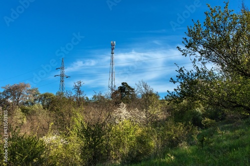 5G radio network telecommunication equipment with radio modules and smart antennas mounted on a metal on blue sky background.