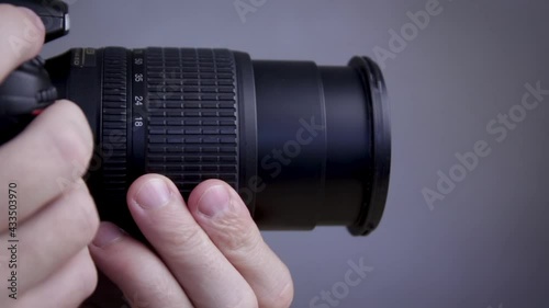Photographer adjusts the aperture on camera. Focus change. Close-up.