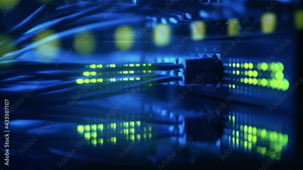 Close-up view of modern internet network switch with plugged ethernet cables. Blinking lights on internet server. Concept of data center. Cloud computing and telecommunications