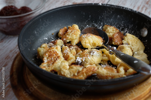 Fresh 'Kaiserschmarrn' in a pan, and plum compote. A traditional sweet meal in Bavaria and Austria.