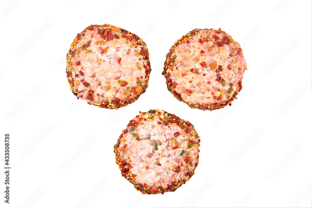 Raw meat patties with spices, three pork cutlets isolated on white Raw meat patties with spices, three pork cutlets isolated on white