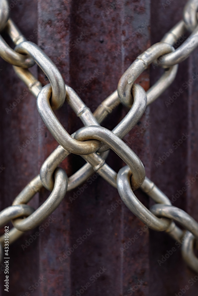 metal chain wraps around rusty iron pillar, steel chains cross with a cross metal chain wraps around rusty iron pillar, steel chains cross with a cross