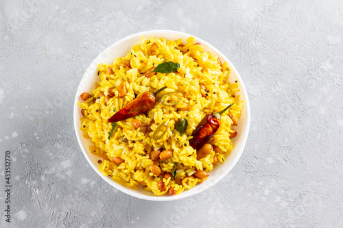 A balti dish with lemon rice, rice flavoured with mustard seeds, curry leaves and green chili in a bowl. Top view with copy space. photo