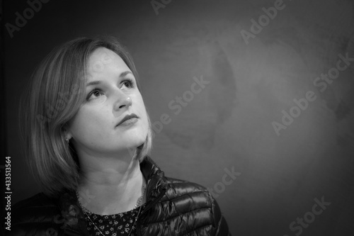 Close-up female portrait looking up away. Adult native caucasian woman portrait. Black and white photo.