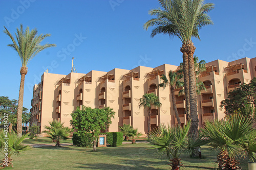 Tropical resort in Egypt. People swimming in sea. Tourists relax on beach