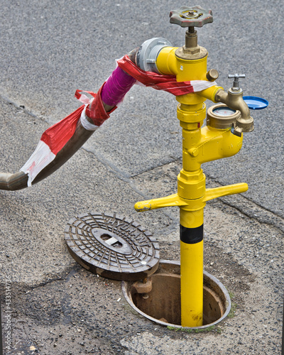 Billede på lærred Der Hydrant auf der Strasse wird zum Wasser zapfen genommen