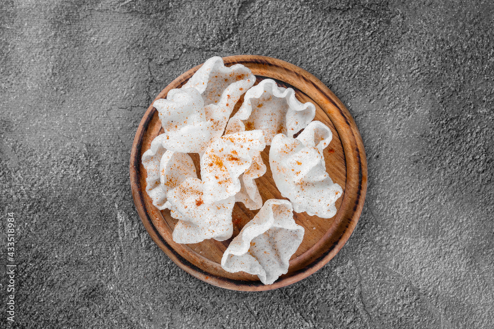 Rice chips on a wooden board on a gray background. Top view. Rice chips on a wooden board on a gray background. Top view.
