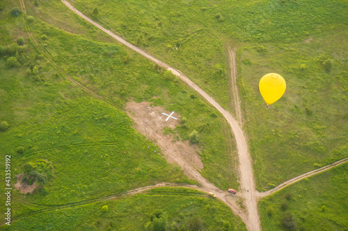 Balloon team is performing the task. Mark on the ground with a cross photo