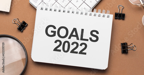 goals 2022 on notepad with pen, glasses and calculator