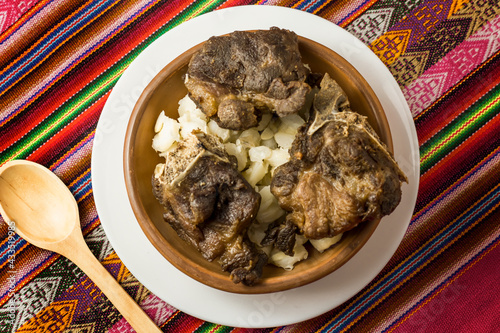 vista cenital de chicarrones de chanco con mote , comida peruana en bol artesanal y manto artesanal de fondo photo