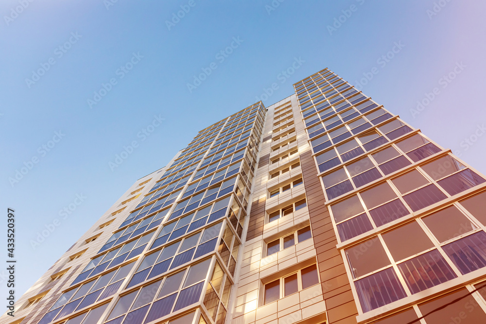 Glazed facade of a multi-storey residential building. Modern apartments in high raised building. Rhythm in photography. The perspective is up. Glazed facade of a multi-storey residential building. Modern apartments in high raised building. Rhythm in photography. The perspective is up.