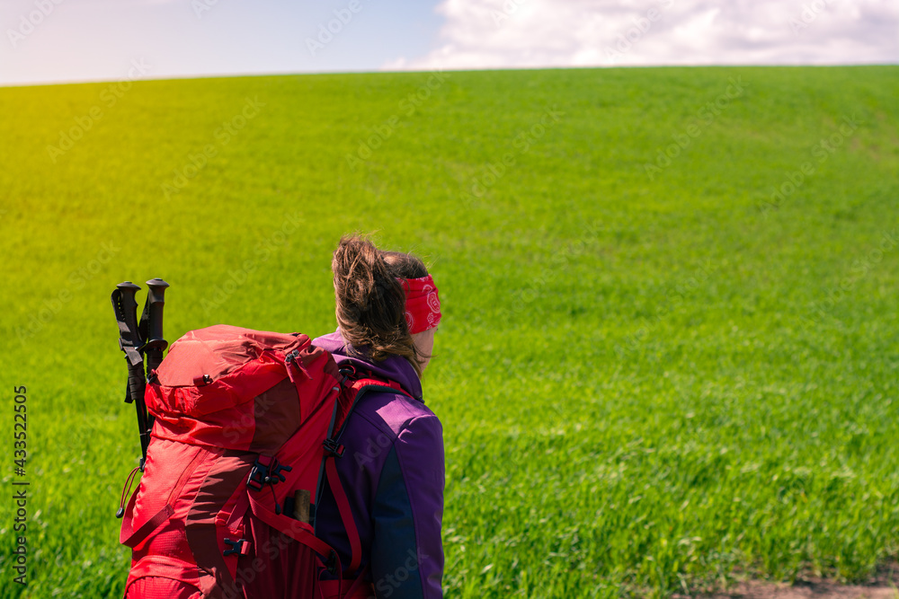 Woman hiking alone with red hiking backpack