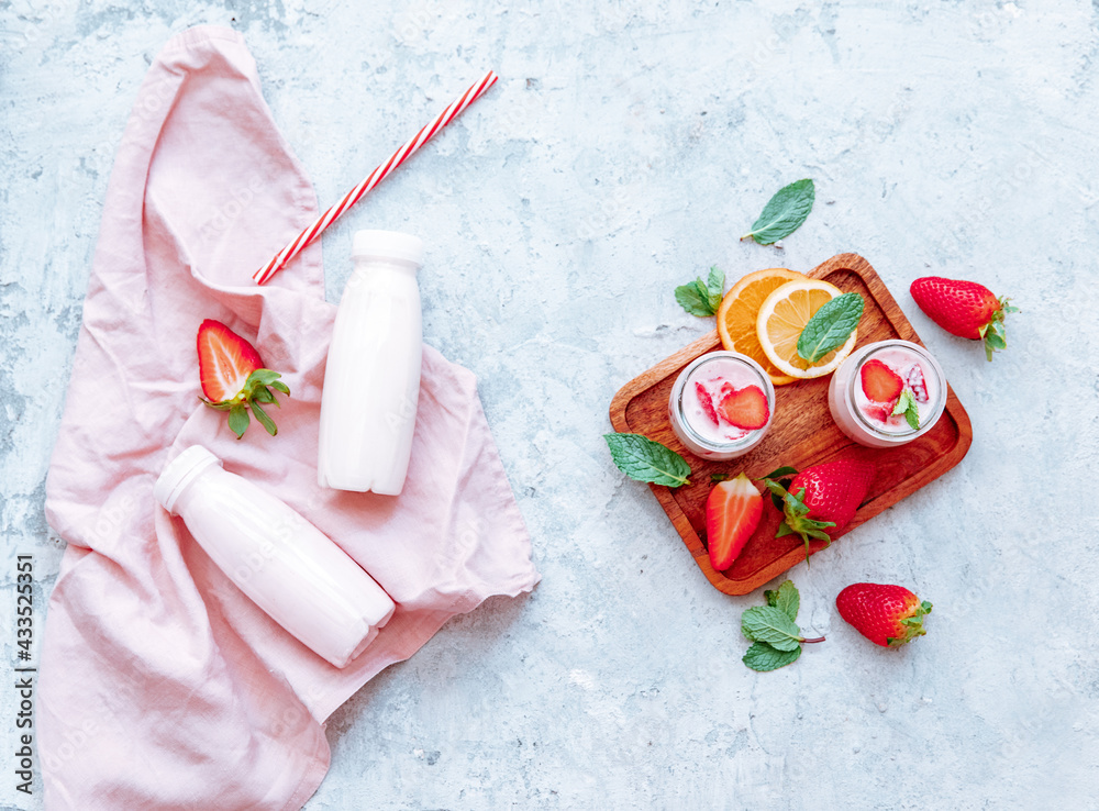 Flat lay Tasty strawberry milk shake in bottle on white background. Strawberry smoothies. Strawberry and yogurt. Top view, flat lay, copy space Flat lay Tasty strawberry milk shake in bottle on white background. Strawberry smoothies. Strawberry and yogurt. Top view, flat lay, copy space